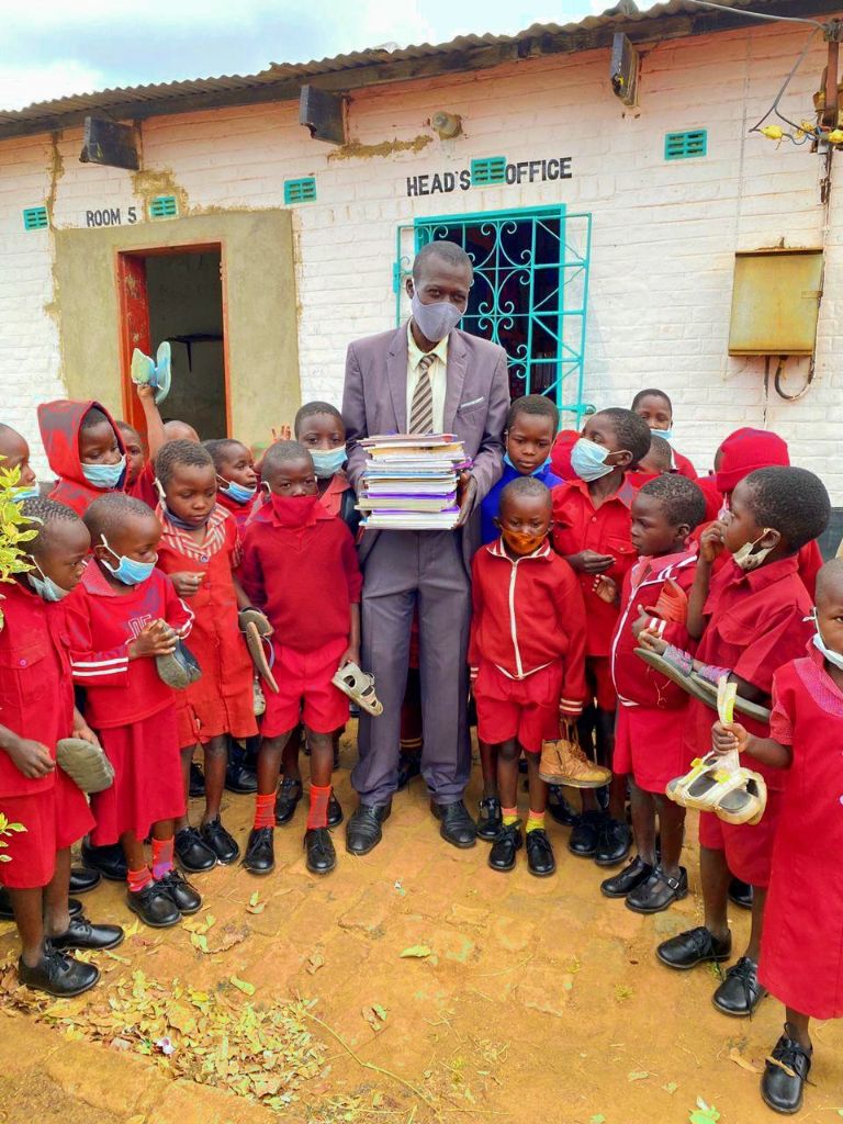 Children and teacher gathered outside a school office